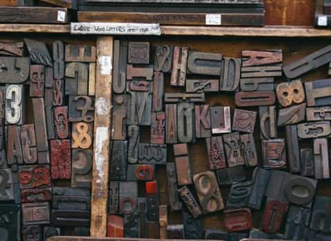 The letters carved on wooden squares lie in a wooden box